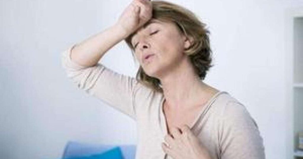 Mulher na menopausa sentindo calor intenso no verão