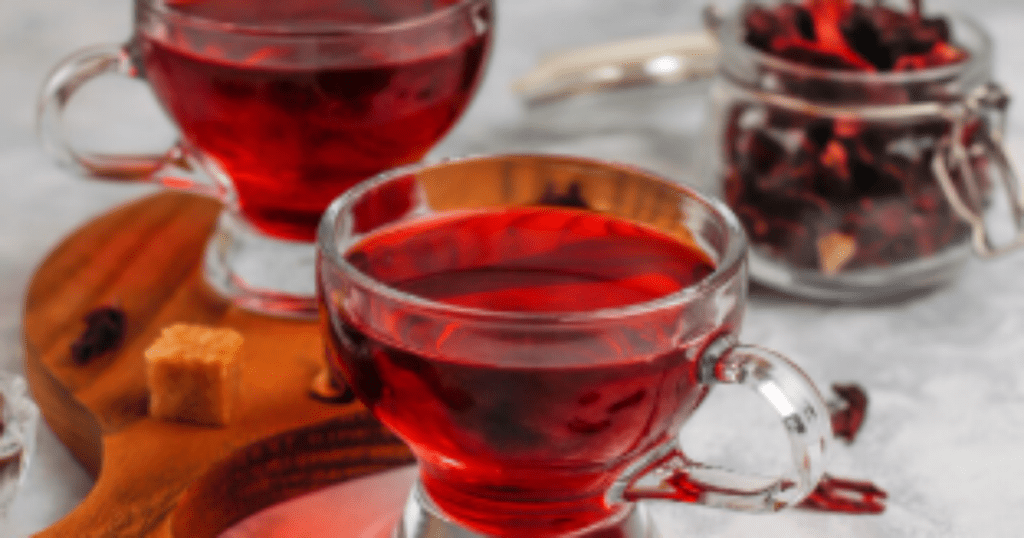 Xícara de chá de hibisco servido quente com flores secas em fundo natural