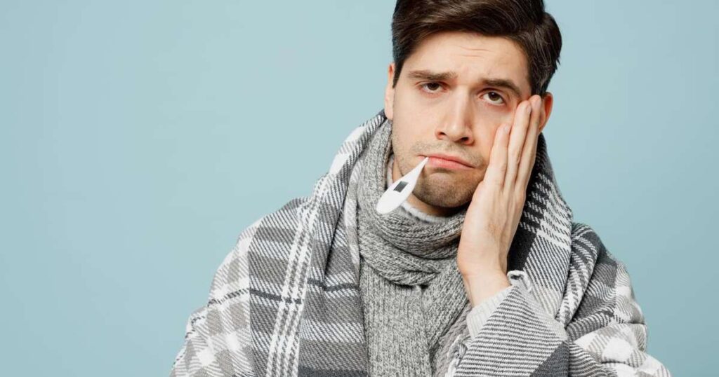 Pessoa aplicando compressa morna na testa para ajudar a baixar a febre