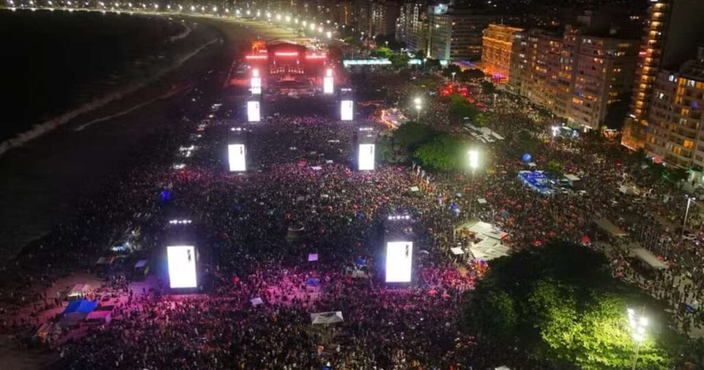 Shakira se apresentando no megashow na Praia de Copacabana, com multidão de fãs ao fundo