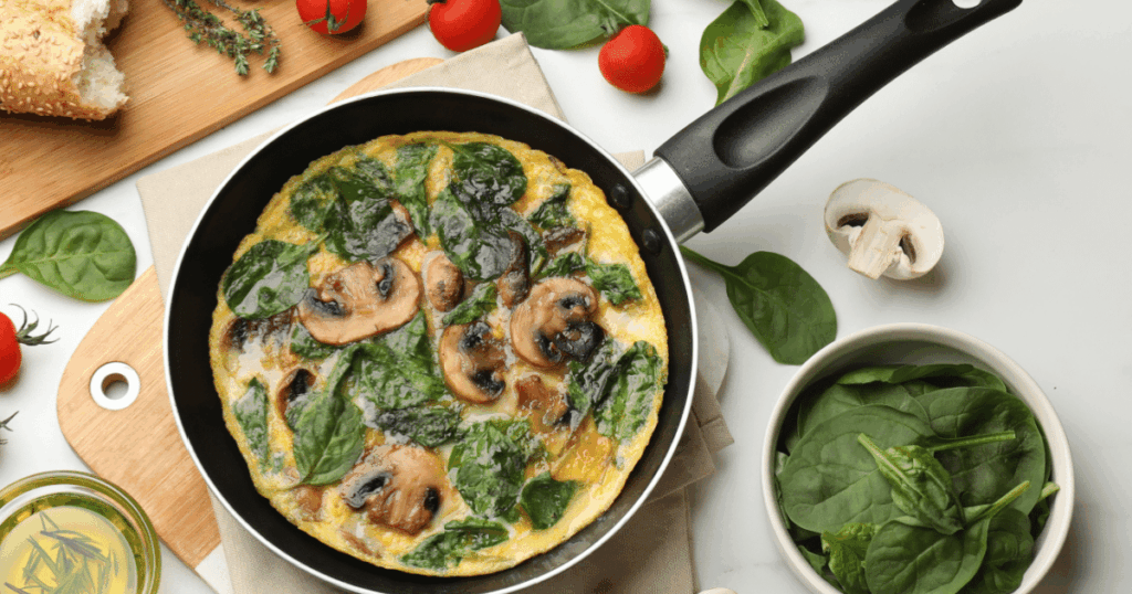 Prato colorido com omelete de cogumelo e espinafre, fígado com pimentões e sardinha ao forno com brócolis, representando refeições saudáveis ricas em vitamina D.