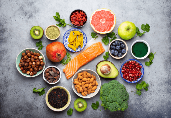Diversos alimentos funcionais em uma mesa, incluindo frutas, vegetais, grãos integrais e produtos lácteos.